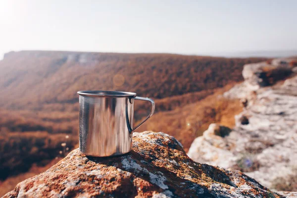 Metal cup on rock in mountain forest. Autumn colors, close up, copyspace. beautiful landscape