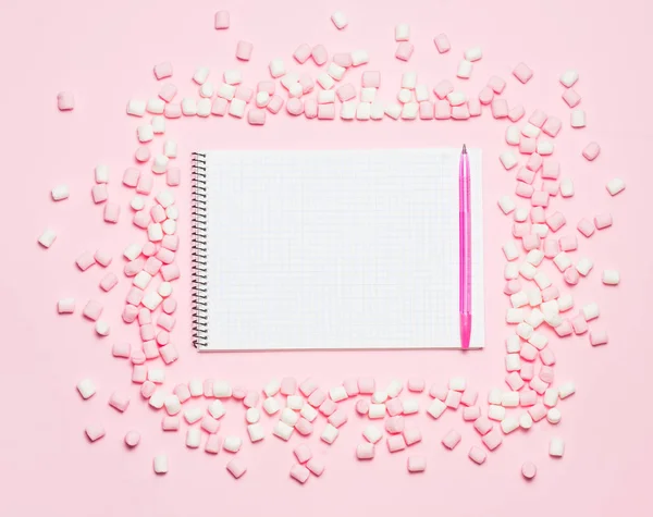 Marco y cuaderno de malvaviscos rosa y blanco sobre fondo rosa Vista superior, plano. espacio libre para su texto —  Fotos de Stock