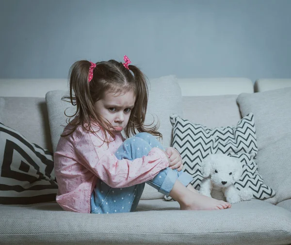 Sad or angry little girl, victim, holding toy dog. — Stock Photo, Image