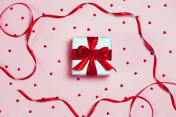 Caja de regalo con brillo brillante sobre fondo rosa. San Valentín romántico concepto de saludos. lugar para su texto. Vista superior, plano — Foto de Stock