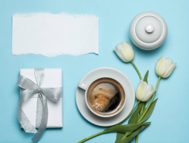 Fincan kahve ve Beyaz Lale mavi zemin üzerine.