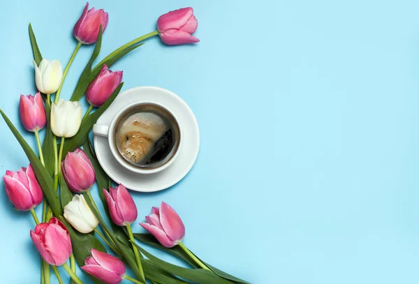 Copa de café y tulipanes rosados sobre fondo azul . —  Fotos de Stock