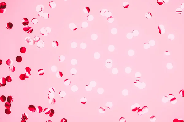 Pink confetti and stars and sparkles on pink background.