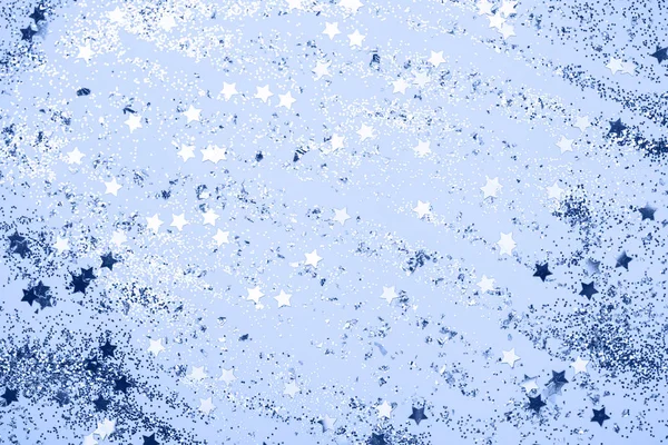 Классические синие конфетти, звезды и искры на голубом фоне. — стоковое фото