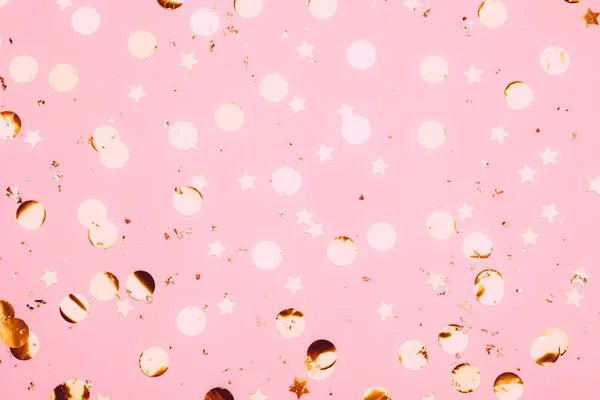 Рожеві конфетті і зірки і блискітки на рожевому фоні . — стокове фото