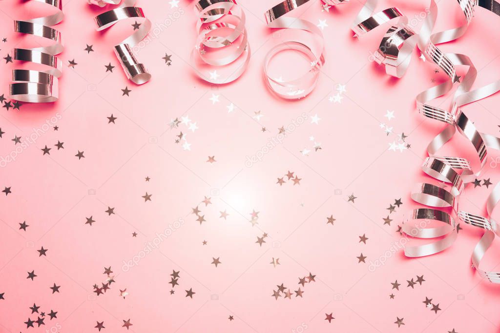 Pink confetti and stars and sparkles on pink background.