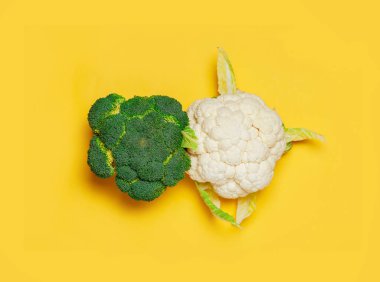 Sarı arka planda brokoli ve karnabahar. asgari vejetaryen kavramı.