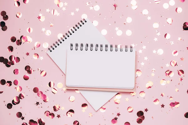 Pusty notatnik na pastelowym różowym tle konfetti. — Zdjęcie stockowe