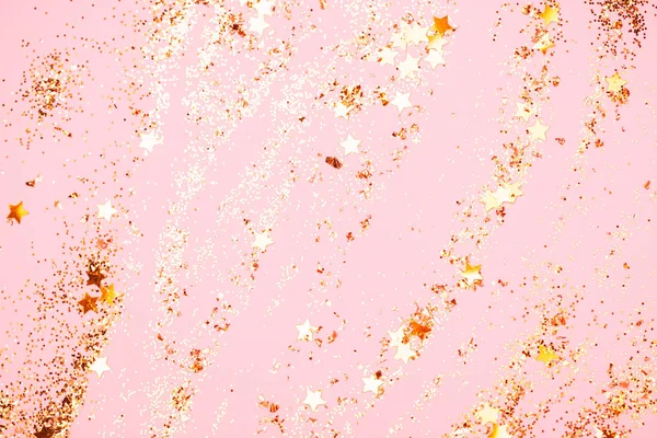 Pink confetti and stars and sparkles on pink background.