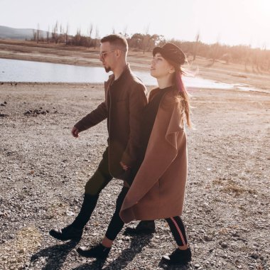 Genç güzel dışında güzel günbatımı üzerinde yürüme çift.