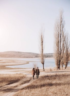 Genç güzel dışında güzel günbatımı üzerinde yürüme çift.