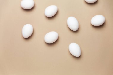 Beyaz yumurtalı yaratıcı Paskalya bej ve pembe arka plan. Paskalya tatili minimum konsept.