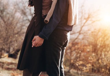 Genç güzel dışında güzel günbatımı üzerinde yürüme çift. Mükemmel romantik manzara lovestory için. İki hipsters-sevgili sarılma.