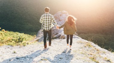 Genç güzel dışında güzel günbatımı üzerinde yürüme çift. Mükemmel romantik manzara lovestory için. İki hipsters-sevgili sarılma.