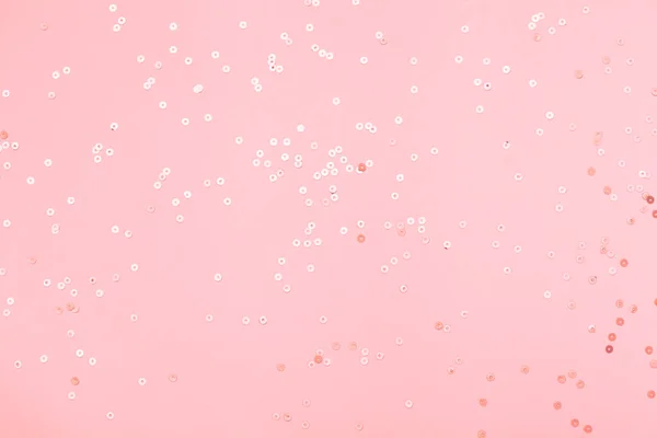 Pink confetti and golden stars and sparkles on pink background. Top view, flat lay. Copyspace for text. Bright and festive holiday background. For Christmas, New year, Mother\'s day.