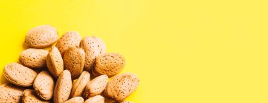 Badem deseni. Parlak sarı arka plan üzerinde badem kabuğu ile yapılan trendy yaz deseni. Minimal yaz konsepti.