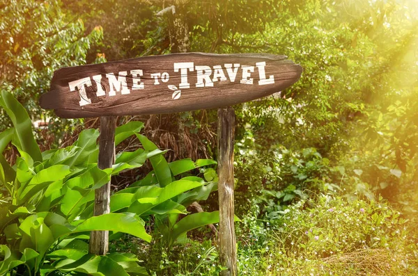 Signo de madera de viaje en el tiempo en el fondo de la selva. Aarrow, palmeras verdes — Foto de Stock