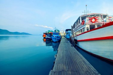 Ulusal, çok renkli turist tekneleri batımında iskelede. Tayland, Bang Bao, Koh Chang Adası demirleme tekne.