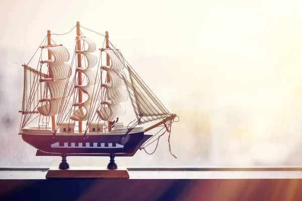 The model of a sailing ship stands on a misted window. The concept of travel. Dreams of a vacation. — Stock Photo, Image