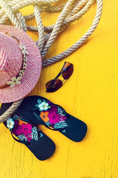 Set of Womans Things Accessories to Beach Season Straw Beach Womans Hat Top View Yellow Background