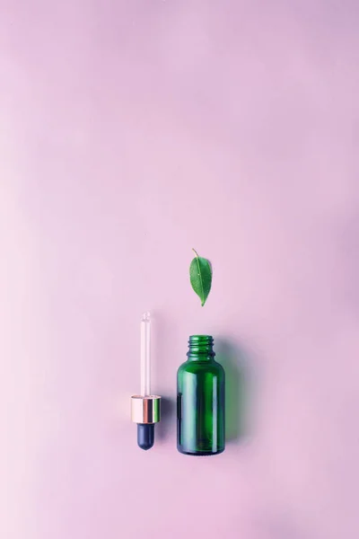 The minimal style. Natural skin care, cosmetics. Eco. Green glass bottle with a pipette in pastel colors. Flat lay. — Stock Photo, Image