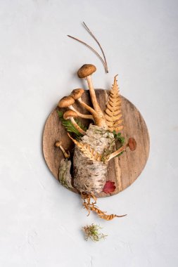 Hafif bir arka plan ve bir ahşap yuvarlak boş tabak taze, çiğ mantar. Arka plan. Kavram minimalizm kopya alanı