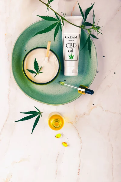 Cosmetics CBD oil on a turquoise plate on a light marble background. Copy space, mockup. — Stock Photo, Image