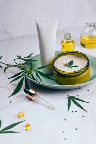 Cosméticos con aceite de cannabis en una placa de color turquesa sobre un fondo de mármol claro. Copiar espacio, maqueta . —  Fotos de Stock