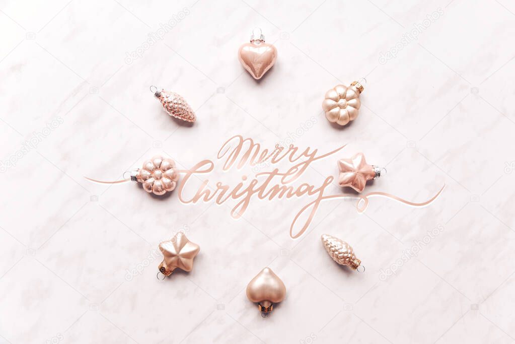 Creative composition of Christmas wreath, circle from decorative ornaments. Lettering Merry Christmas Flat lay, pastel. Minimalism.