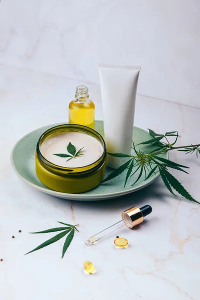 Cosméticos con aceite de cannabis en una placa de color turquesa sobre un fondo de mármol claro. Copiar espacio, maqueta . —  Fotos de Stock