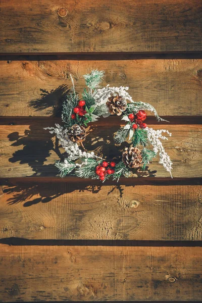 Christmas wreath on wooden door decoration. Minimal winter vacation idea.