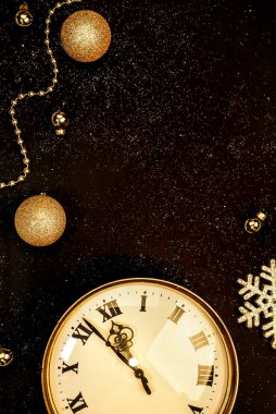 Gold vintage clock decorated with christmas balls on a black background in sparkles. Twelve oclock, New Year 2020 is coming. Copy space clipart