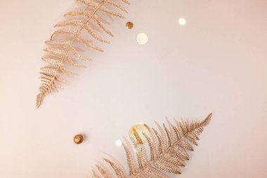 Kutlama kompozisyonu. Parlak Noel dekoratif çiçek dalları, konfeti, bej arka planda altın parıltılar. Düz yatıyordu. Uzayı kopyala Şık Noel konsepti Minimalizm