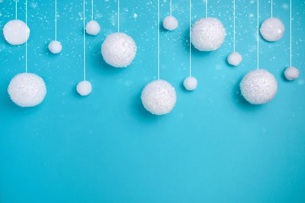 Composição de Natal. O conceito de um fundo festivo de inverno, nevasca de bolas brancas em um fundo azul. Natal, inverno, conceito de ano novo. Minimalismo flat lay — Fotografia de Stock