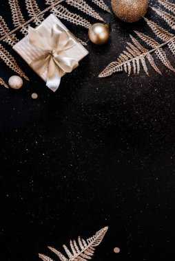 Noel arkaplanı. Bayram hediyeleri beyaz kutularda, şenlikli dekorları ve simli siyah arka planda parlak dalları var. Düz konum, üst görünüm, kopyalama alanı