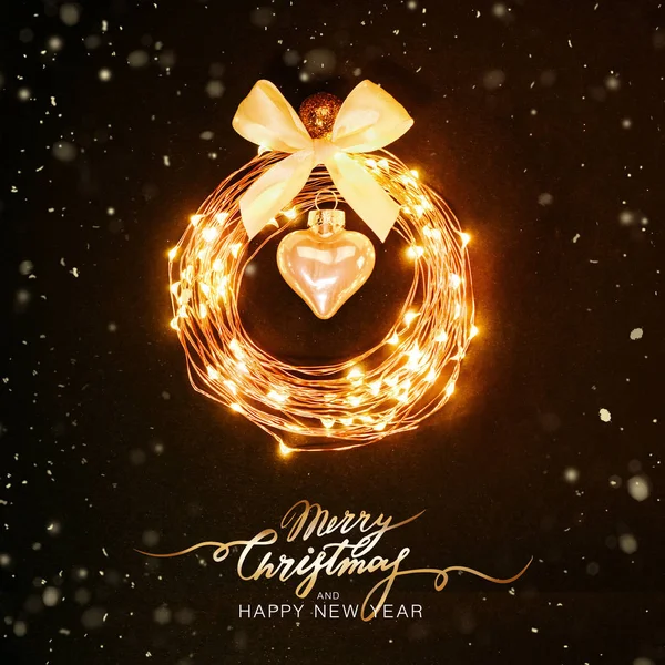 Christmas background. Glowing circle from a garland in the form of a Christmas toy on a black background with glitters. Festive design concept Lettering — Stock Photo, Image