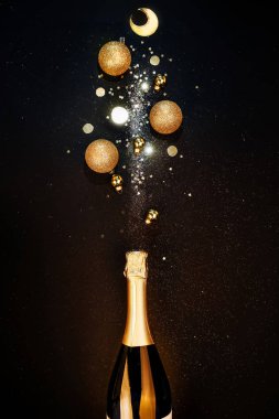Noel arkaplanı şenliği. Bir şişe şampanya, bir tutam ışıltı ve Noel süslemeleri..