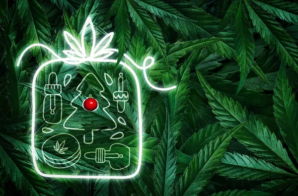 Creatieve fluorescerende kerst achtergrond lay-out van hennepbladeren, marihuana en een neon teken cadeau. Vlakke plaat — Stockfoto