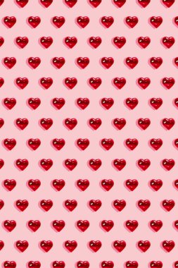 Sevgililer Günü geçmişi. Pastel pembe arka planda cam kırmızı kalpler. Kart minimalizmi, aşkın sembolü