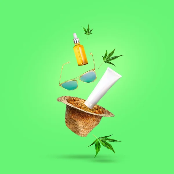 CBD Aceite y cosméticos con hoja de vasos de marihuana y un sombrero volando en antigravedad. Concepto cannabis de verano —  Fotos de Stock