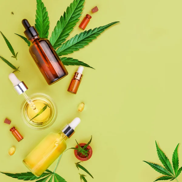 Glass bottles with CBD oil, THC tincture and hemp leaves on green background. Flat lay, minimalism. Cosmetics CBD hemp oil. — Stock Photo, Image