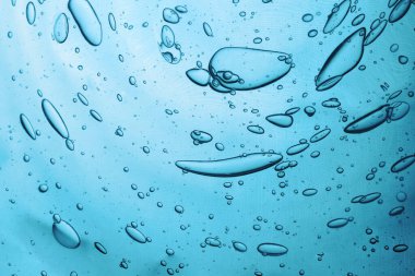 Hyaluronik asit kozmetik jel köpüklü su dokusu. Mavi arka planda kabarcıklı jel dokusu.