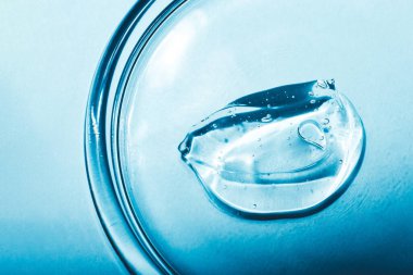 Hyaluronik asit dokusu, serum jeli. Mavi arkaplanda izole edilmiş şeffaf jel lekesi