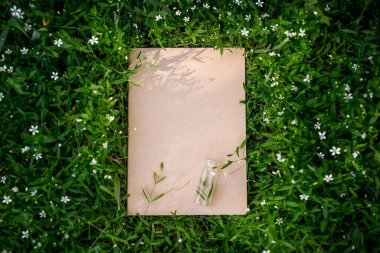 Doğal yaprakların ve çayır otlarının yaratıcı yeşil çiçek arkaplanı. Kraft kağıt çerçevesi