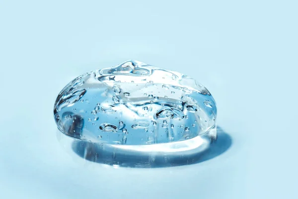 Textura de ácido hialurônico, gel de soro, implantes de silicone, esfregaço transparente de gel sobre fundo azul — Fotografia de Stock