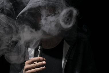 Genç kişi olan vaping bulut daireler yapıyor. 