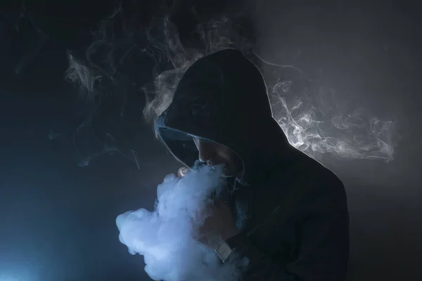 Mann zündet sich eine elektronische Zigarette mit viel Rauch an. — Stockfoto