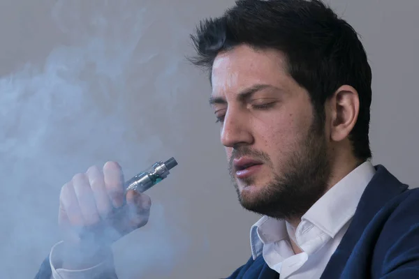 Hombre vapear un cigarrillo electrónico con mucho humo . — Foto de Stock
