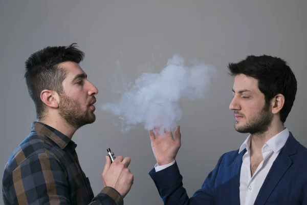 Mannen vape en elektronisk cigarett med massor av rök. — Stockfoto