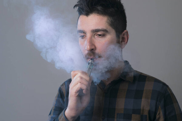 man vape an electronic cigarette with lots of smoke. 
